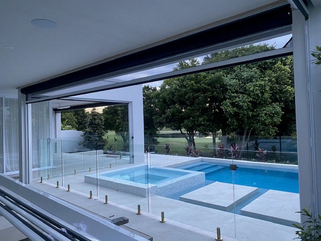 Retractable screen fully retracted showing an uninterrupted pool and garden view